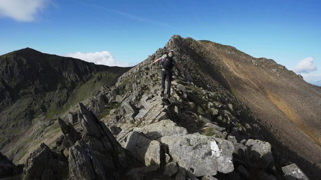A man walking dangerously on Crib Goch ridge in Snowdonia national park Wales
