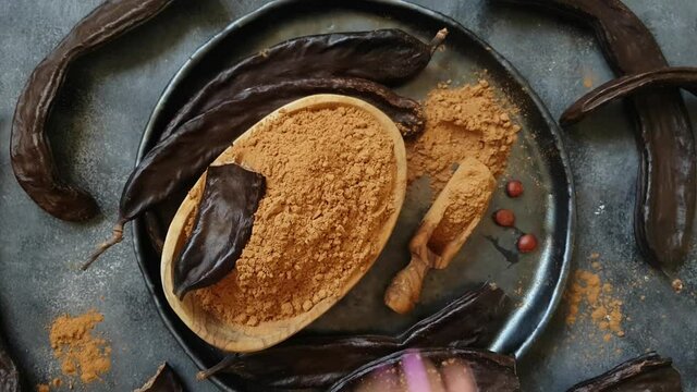 Dry carob pods and powder top view