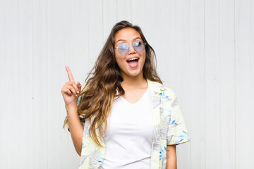 young pretty woman feeling like a happy and excited genius after realizing an idea, cheerfully...