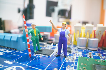 Miniature repair man on mainboard, Miniature figure of worker team try to repair cpu on mainboard.