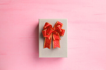 Gift box with red ribbon on pink background, present for giving in special day, Top view