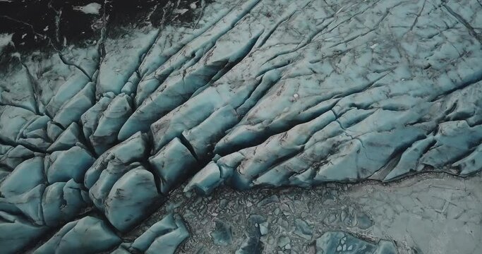 Heinaberg Glacier in Iceland
Top down view of glacier, white and blue cracked ice cap partially covered with black volcanic ash. 4 k drone fottage of Heinaberg in Iceland.