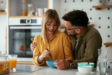 Young couple making sandwich at home. Loving couple enjoying in the kitchen..