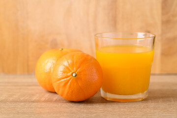 Fresh Honey Murcott orange fruit and juice on wooden background