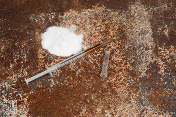 Syringe and drugs on dirty rusty background. Injection syringe. addiction