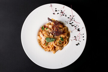 Pasta on white dish on black background.  For menu