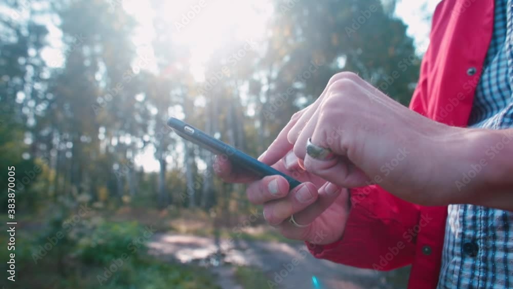 Poster close-up of using a mobile phone on a sunny day. the hand scrolls across the screen, shows the sign 