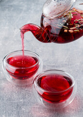 red tea is poured from a teapot into a bowl