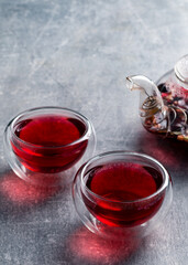 red tea is poured from a teapot into a bowl