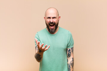 young bald and bearded man looking angry, annoyed and frustrated screaming wtf or what‚Äôs...