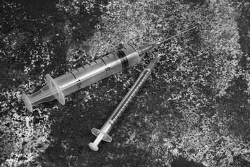 Syringe and drugs on dirty rusty background. Injection syringe. addiction. black and white photo