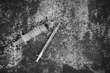 Syringe and drugs on dirty rusty background. Injection syringe. addiction. black and white photo