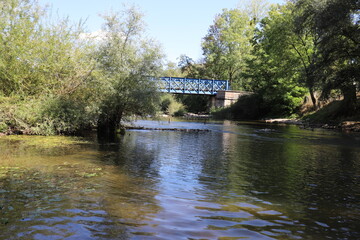 Beautiful old French railway bridge above a river. Photo was taken on a sunny day with an awesome blue sky.