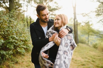 gentle and stylish couple are having a walk in the autumn park