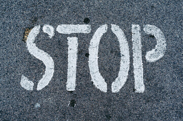 Inscription stop en blanc sur du béton gris - Arrière plan urbain