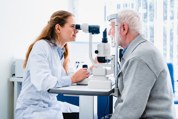 Female ophthalmologist examining mature man`s eyes