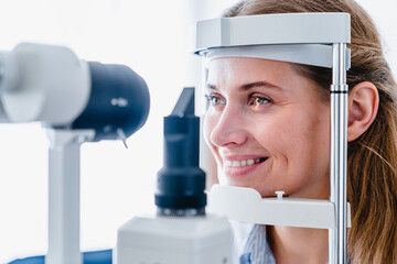 Close up photo of a smiling young woman patient during ophthalmic sight examination
