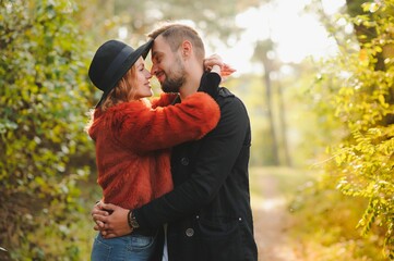 love, relationship, family, season and people concept - smiling couple hugging over autumn natural background