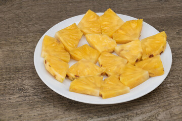 Slices of pineapple on a plate, The benefits of pineapple, Wooden Background