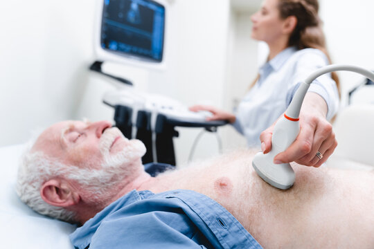 Cropped photo of a senior male patient heart examination with ultrasound by woman doctor