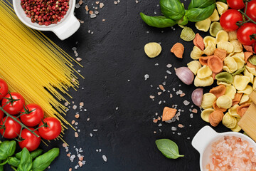 Italian Pasta orecchiette with traditional ingredients for the preparation food on black background. Culinary food cooking background. Top view.