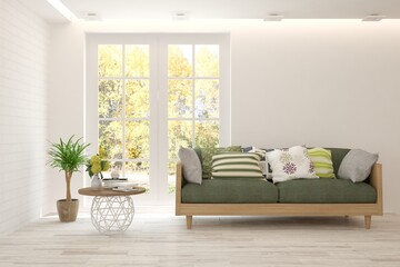 Stylish room in white color with sofa and autumn landscape in window. Scandinavian interior design. 3D illustration