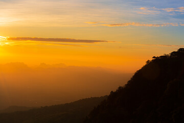 Beautiful landscape nature in morning on peak mountain with sunlight cloud fog and bright blue sky in winter at Phu Chi Fa Forest Park is a famous tourist attraction of Chiang Rai Province, Thailand