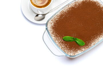 Traditional Italian Tiramisu dessert in glass baking dish and cup of fresh espresso coffee isolated on white background with clipping path