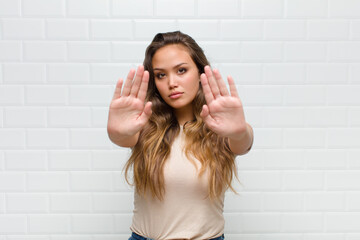 looking serious, unhappy, angry and displeased forbidding entry or saying stop with both open palms