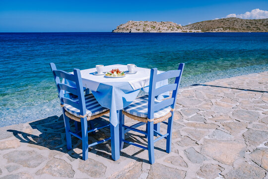 Crete Greece Plaka Lassithi with is traditional blue table and chairs and the beach in Crete Greece. Paralia Plakas, Plaka village Crete