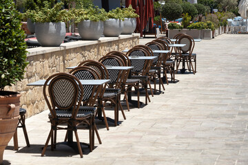 Empty tables and chairs at street cafe