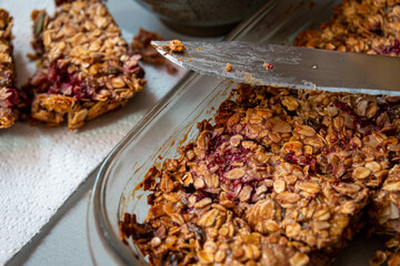 home made cereal bars in cooking dish with knife.