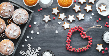 Obraz na płótnie Canvas Christmas background with star cookies, tasty lemon muffins, winter decor with fir and berries.