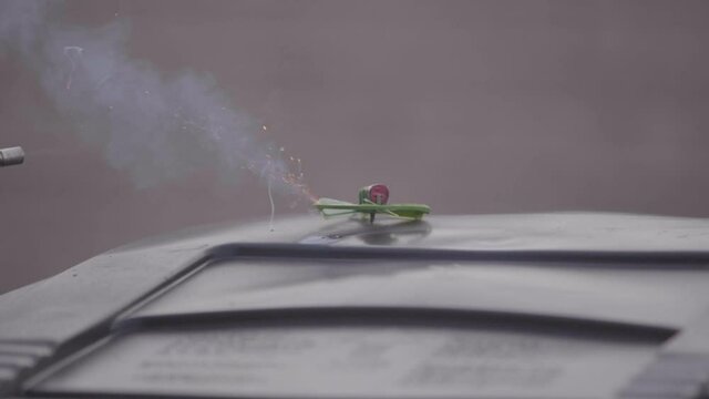 Lighting an areal firework with a mini blow torch.  the fuse ignites and begins to burn.