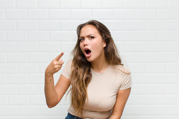 pointing at camera with an angry aggressive expression looking like a furious, crazy boss