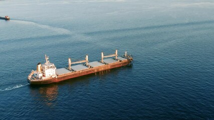 Cargo ship sailing on the ocean to the sea port. A bulk carrier or bulker - a merchant ship specially designed to transport unpackaged bulk cargo, such as grains, ore, coal or timber