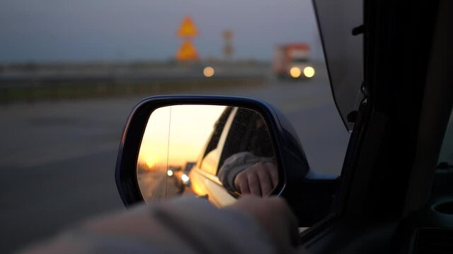 Family trip. The family is driving on the highway. Reflection in the mirror. Sunset time