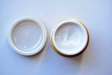 Yellow and white jar with white cosmetic cream
