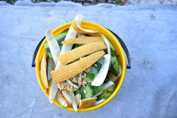 Yellow and white bucket with food waste of vegetables and fruits