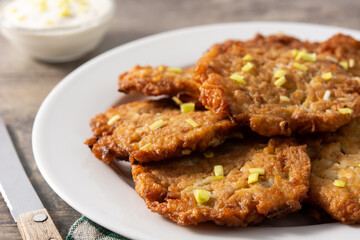 Traditional Jewish latkes or potato pancakes on wooden table