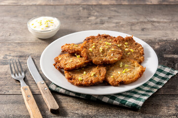 Traditional Jewish latkes or potato pancakes on wooden table