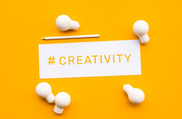 Business creativity concepts with text on notepaper and lightbulb on yellow background