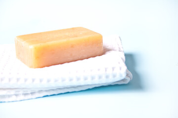 soap bar on white bath towel, light blue background