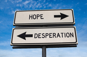 Hope vs desperation. White two street signs with arrow on metal pole with word. Directional road. Crossroads Road Sign, Two Arrow. Blue sky background. Two way road sign with text.