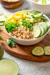Burrito bowl with quinoa and green vegetables. Salad of quinoa, cucumber, peppers, radishes and celery in a bowl close-up. Healthy diet food, vegetarian food.