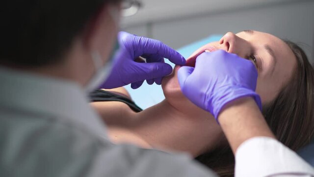 Dentist or dental hygienist with patient talking about operation. Checkup with orthodontist or odontologist. Oral doctor before removing wisdom teeth. Dentistry. Specialist operating.