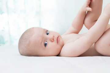 Cute baby girl lying on bed