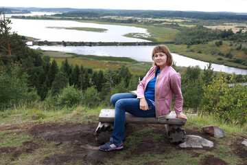 Naklejka na ściany i meble Woman sitting on bench On Mount Paaso in Karelia
