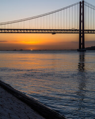 Fototapeta na wymiar Sunrise by the 25 de Abril Bridge in Lisbon