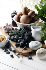 Spinach and spirulina pasta, mushrooms, onions, garlic, pine nuts, coconut milk, black pepper and parsley on the table